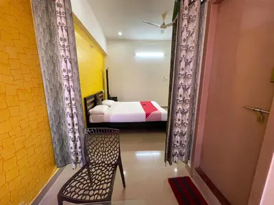 a bedroom with a bed and a chair in a room at Green Valley Residency in Gundlupet