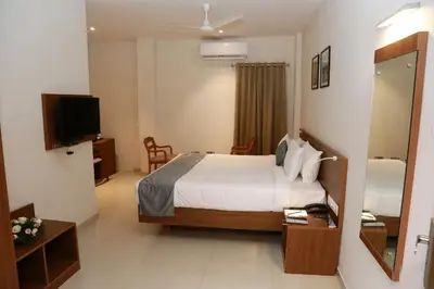 a hotel room with a bed and a television at Hotel Picnic in Manjeri