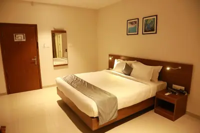 a bedroom with a large bed and a mirror at Hotel Picnic in Manjeri