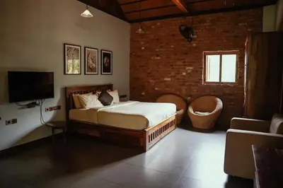 a bedroom with a bed and a tv and a couch at BARSATI Ranches in Vythiri