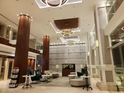 a lobby with couches and chairs in a building at Hotel Amaravathi in Mandya