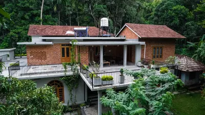 a brick house with a balcony in front of it at the motville - Serene Family Retreat & Private Pool in Pulpally