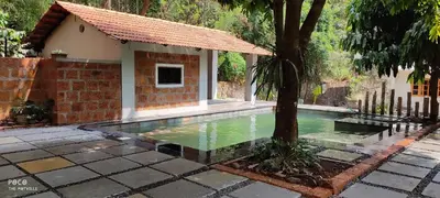 a swimming pool in front of a house with a tree at the motville - Serene Family Retreat & Private Pool in Pulpally