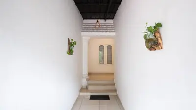 a hallway of a house with white columns at Riviera inn resort in Chillithodu