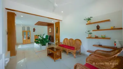 a living room with chairs and a couch and a tv at Riviera inn resort in Chillithodu