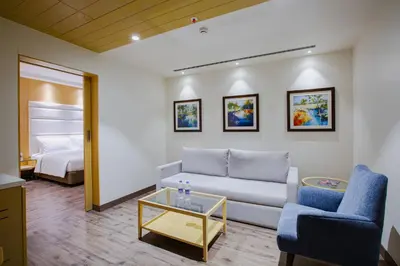 a living room with a couch and a bed at IKON By Annapoorna in Coimbatore