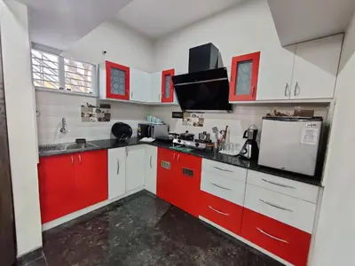 a kitchen with red and white cabinets at Royal Wings Apartments in Mysore