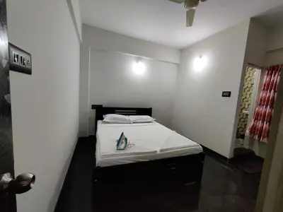 a small bedroom with a bed in a room at Royal Wings Apartments in Mysore