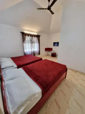 a bedroom with a large bed with a red blanket at Royal Mist in Ooty