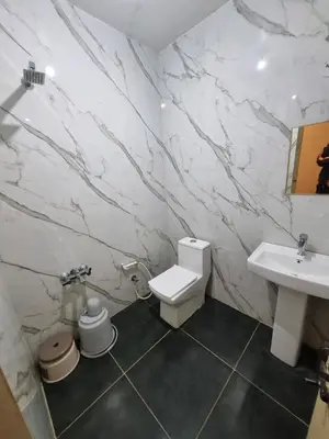 a bathroom with a white toilet and a sink at Royal Mist in Ooty