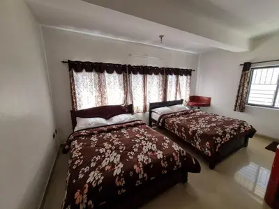 a bedroom with two beds and a window at Royal Mist in Ooty