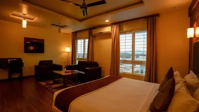 a hotel room with a large bed and a desk at National Residency in Mysore