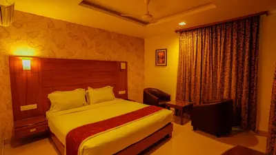 a hotel room with a bed and a chair at National Residency in Mysore