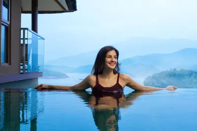 a woman in a swimming pool in the water at MOUNTAIN SHADOWS RESORT Wayanad in Wayanad