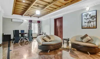 a living room with two chairs and a table at Treebo Symphony Hotels And Resorts Angamally in Kizhake Chālakudi