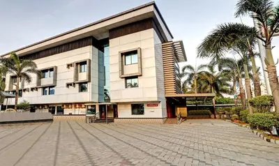 a large building with palm trees in front of it at Treebo Symphony Hotels And Resorts Angamally in Kizhake Chālakudi