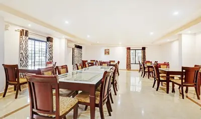 a dining room with wooden tables and chairs at Treebo Symphony Hotels And Resorts Angamally in Kizhake Chālakudi
