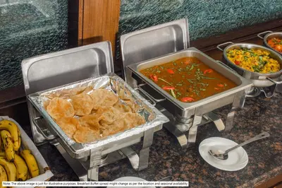 two trays of food sitting on a counter with food at Treebo Symphony Hotels And Resorts Angamally in Kizhake Chālakudi