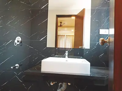 a bathroom with a white sink and a mirror at HOTEL VINTAGE CASTLE in Coimbatore