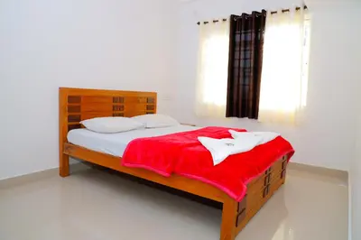 a bedroom with a wooden bed with a red blanket at The Coorg Heaven in Madikeri