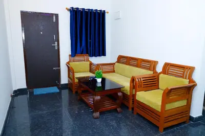 a room with chairs and a table and a door at The Coorg Heaven in Madikeri
