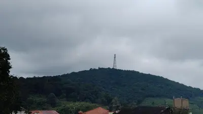 a mountain with a tower on top of it at The Coorg Heaven in Madikeri