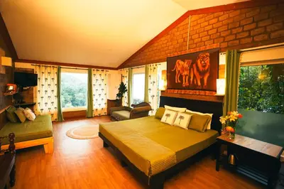 a bedroom with a bed and a couch in a room at De Rock Jungle Living Resort in Coonoor