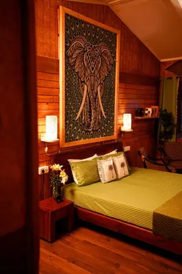 a bedroom with a bed with a painting of an elephant at De Rock Jungle Living Resort in Coonoor