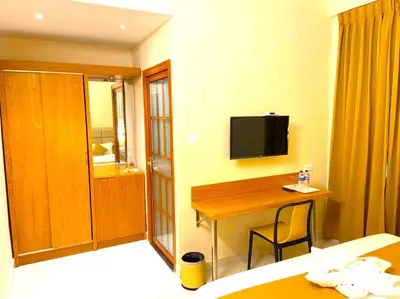 a hotel room with a desk and a tv on the wall at TAG HOTELS in Irugūr