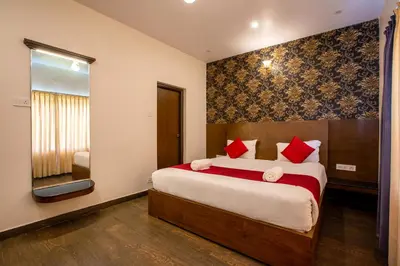 a bedroom with a large bed with red pillows at The Baron in Ooty