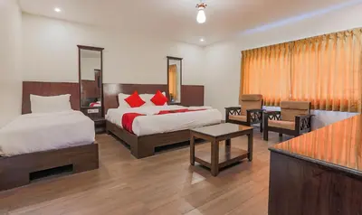 a hotel room with two beds and a table at The Baron in Ooty