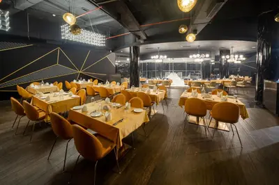 a restaurant with wooden tables and yellow chairs at Fezinn Hotel - Best Wayanad Hotel in 2024 in Kozhikode