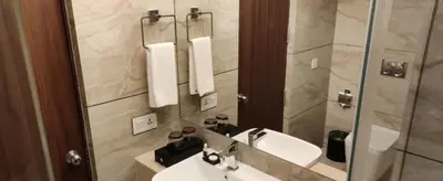a bathroom with a sink and a mirror at Fezinn Hotel - Best Wayanad Hotel in 2024 in Kozhikode