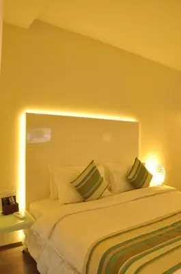 a bedroom with a large white bed with two pillows at The Arcadia Coimbatore Airport in Coimbatore