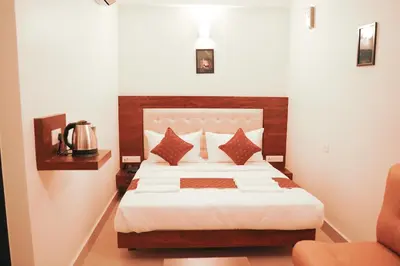 a hotel room with a bed and a chair at ADVAITHA RESIDENCY in Mysore