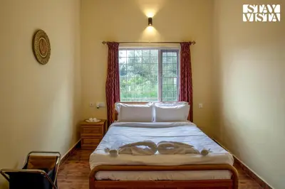 a bedroom with a large bed with a window at StayVista at Zolas Retreat 2BHK Pet Friendly and Breakfast Included in Coonoor