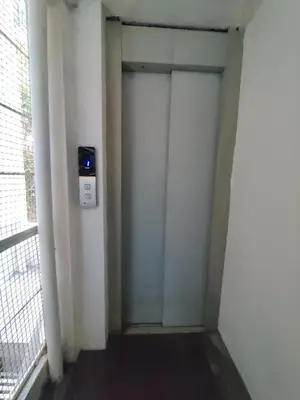 a corridor with two doors in a room with a window at Vogel's Nest in Mysore
