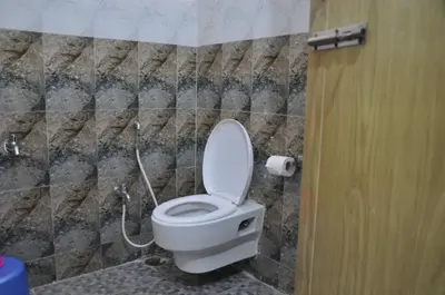 a bathroom with a white toilet in a room at C M HOTEL NEW in Wodapatti