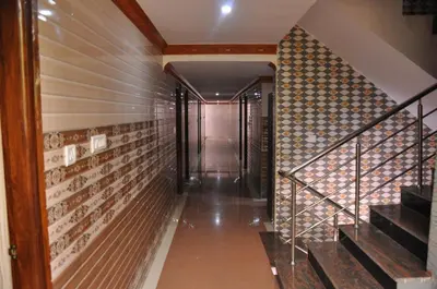 a hallway with stairs and a wall of wine bottles at C M HOTEL NEW in Wodapatti