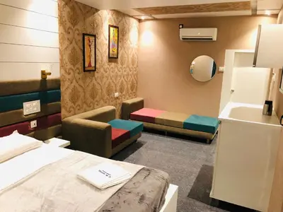 a room with a bed and a couch and a sink at C M HOTEL NEW in Wodapatti
