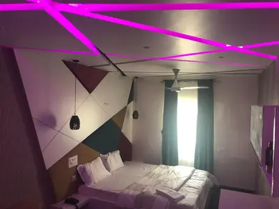 a bedroom with a bed with purple lights on it at C M HOTEL NEW in Wodapatti