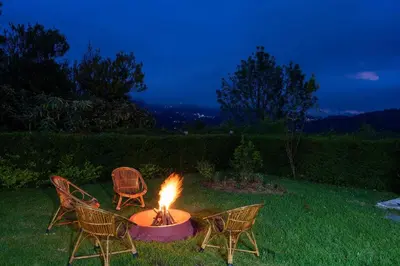 two chairs and a fire pit in a yard at StayVista at Casa Pinnacle - Pet Friendly Home with Lawn in Coonoor