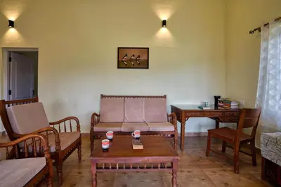 a living room with a couch and chairs and a table at StayVista at Casa Pinnacle - Pet Friendly Home with Lawn in Coonoor