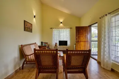 a dining room with a table and chairs and a television at StayVista at Casa Pinnacle - Pet Friendly Home with Lawn in Coonoor