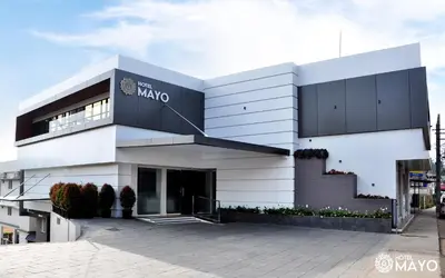 a large white building with a sign on it at Hotel Mayo in Wayanad