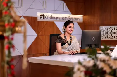 a woman sitting at a desk with a computer at Krishnavalsam Regency in Guruvāyūr