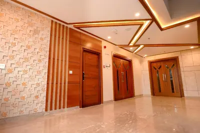 a hallway with wooden doors and tile walls at Krishnavalsam Regency in Guruvāyūr