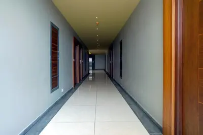 an empty hallway with white walls and white tile floors at Nexstay River Mouth International in Ferokh