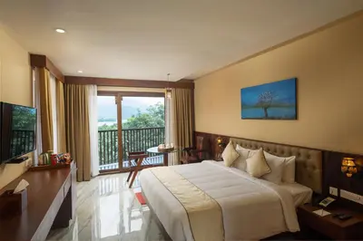 a hotel room with a bed and a balcony at Au Revoir Wellness Resort, Malampuzha in Palakkad