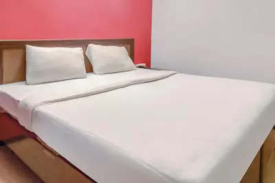 a large white bed with two pillows on it at Hotel O Kota Lodge in Coimbatore